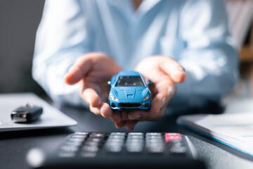 Car finance and insurance concept. Young woman selling or buying car online. Blur with office...