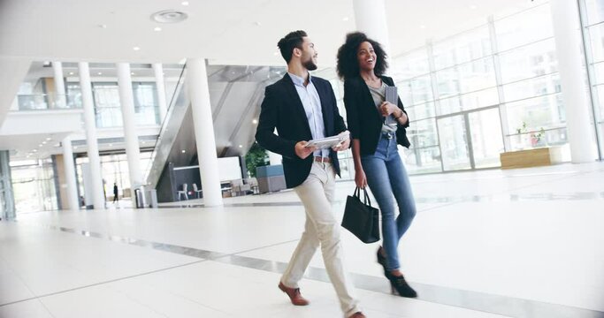 Walking, talking and businessman with woman in lobby for planning, conversation and smile together. Team discussion, agenda and happy business people in office hallway consulting or networking.