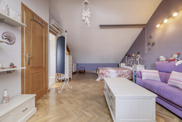 Room with white and purple painted walls, French oak parquet floors, white wooden furniture in the attics of a detached house