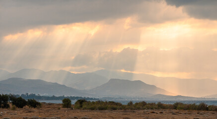 sunlight through the clouds of autumn sunset evening on the Mediterranean sea against the backdrop of mountains 2