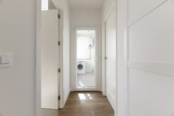 Hallway of a residential house with custom built-in wardrobes with white lacquered wooden doors,...