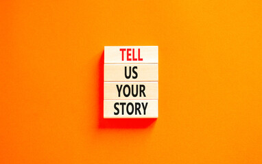 Tell us your story symbol. Concept word Tell us your story on beautiful wooden block. Beautiful orange table orange background. Business tell us your story concept. Copy space.