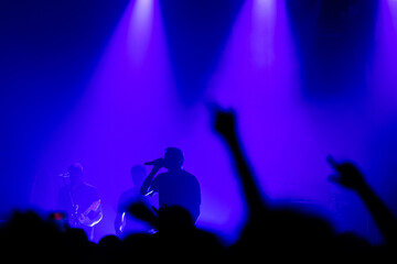 Audience beneath blue lights - rock concert