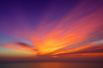 Naklejka na ściany i meble 夕暮れ時の海上から見た、オレンジとピンク、紫のグラデーションが美しい空に浮かぶ繊細な雲、そして水平線に沈む太陽の光景