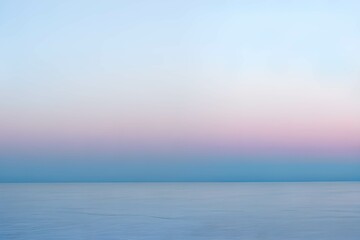 夕暮れの穏やか薄いブルーとピンクが混ざるパステルカラーの海と空の海岸線