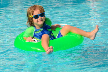 Swimming lessons at the hotel. Child at the resort. Boy in a bathing suit near the pool.