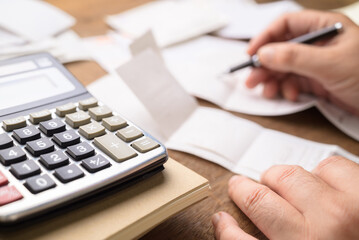 Closeup calculator on the desk with man calculating the bills on background, accountancy, tex calculating concept