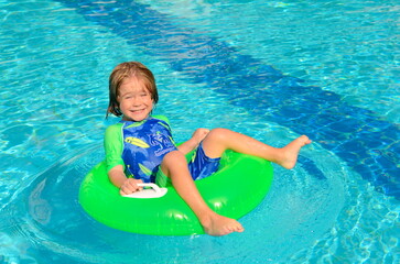 The child enjoys summer. Traveling with children. family resort. Boy swimming in the pool