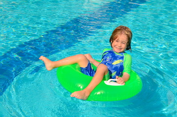 The child enjoys summer. Traveling with children. family resort. Boy swimming in the pool