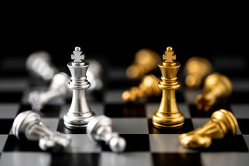 Golden and Silver King chess standing in front of other chess on chess board.