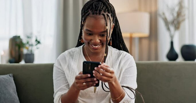 Black woman on sofa, relax or typing on phone for meme, social media or blog post with smile in home. Happy girl on sofa with smartphone checking email, funny website or online chat in living room.