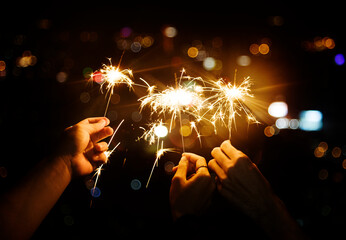 Celebrating the New Year: Sparkling Joy with Burning Sparklers in the Night