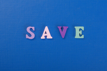SAVE word on blue background composed from colorful abc alphabet block wooden letters, copy space for ad text. Learning english concept.