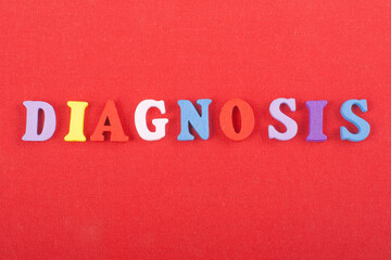Fototapeta na wymiar DIAGNOSIS word on red background composed from colorful abc alphabet block wooden letters, copy space for ad text. Learning english concept.