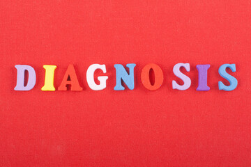 DIAGNOSIS word on red background composed from colorful abc alphabet block wooden letters, copy space for ad text. Learning english concept.