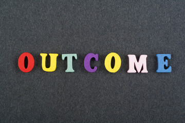 OUTCOME word on black board background composed from colorful abc alphabet block wooden letters,...