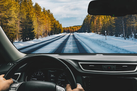 Man driving car on frozen snow country road in winter Finland.