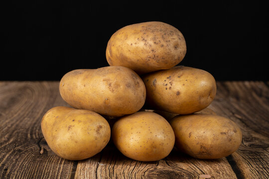 White potatoes on a dark background. Sale of fresh potatoes.