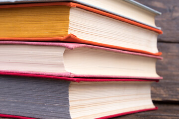 Multi-colored books on wooden table. Back to school. Copy space for text. Education business concept.