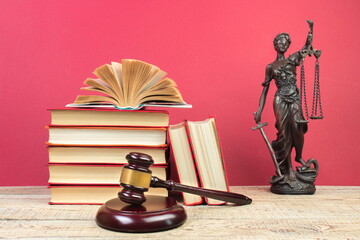 Law concept - Open law book, Judge's gavel, scales, Themis statue on table in a courtroom or law...