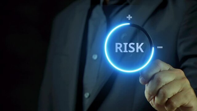 Business man is using magnify glass. showing RISK word. Financial and security concept.