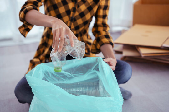 Women squeeze plastic bottle and putting in plastic bag for recycling and conservation environment
