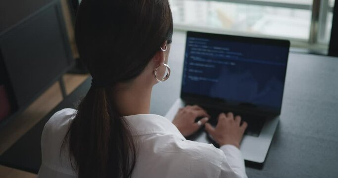 Woman programer typing code on computer keyboard to develop new app server. Software engineer typing code on algorithm on terminal window html script. Developing concept typing code. Back rear view