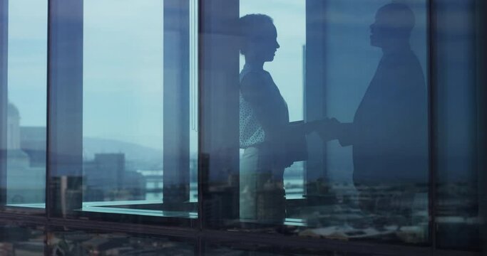 Business, woman and man with shadow, shaking hands and talking for interview outdoor in city building. People, professional or employees with documents for proposal, discussion and onboarding at work