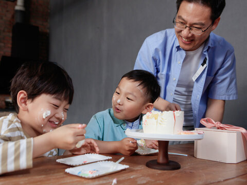 Father and sons eat cake