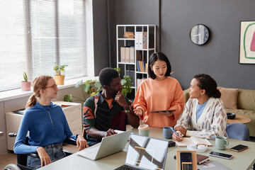Diverse team of young people discussing IT project during meeting in office