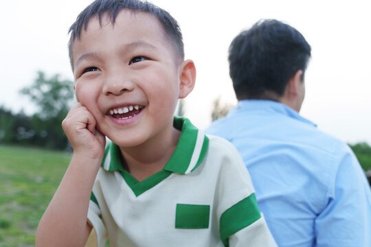 Outdoor back-to-back happy father and son