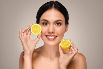 Positive young caucasian lady with perfect face, show yellow lemons fruits