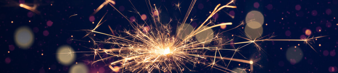 Burning sparkler with  bokeh light on blue background. New year party background. New year sparkles.