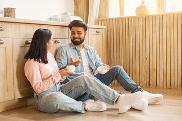 Young Hindu couple chatting over coffee at home in kitchen