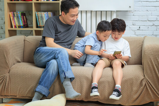 Happy father and children are on the sofa