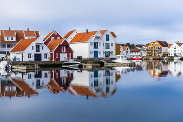 Houses and boats are reflected in the water - obrazy, fototapety, plakaty