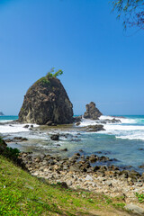 Rocky shoreline of Watu Lumbung Beach, Indonesia. Tidal waves hits the coral rock