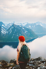 Woman tourist traveling in Norway girl hiking alone outdoor with backpack enjoying mountains view...