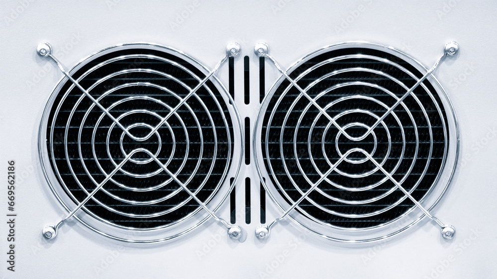 Poster an air fan behind a metal grille installed on a modern computer ac power supply unit. cooling the co