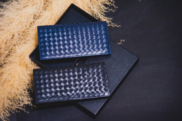 High quality genuine leather wallet in two colors, stacked on top of a black package box. On a...