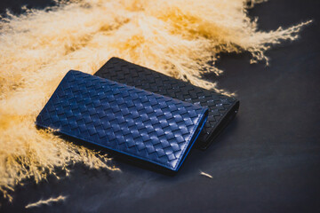 High-quality genuine leather wallets, available in two colors, stacked on top of a black packaging...