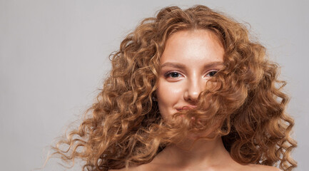 Happy hair model. Beautiful woman with wavy hairstyle. Pretty young woman with curly hair