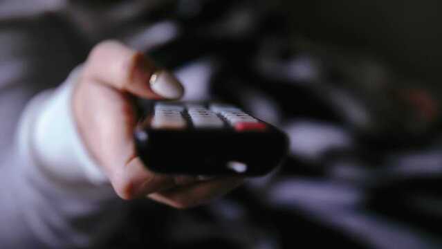 Close-Up TV Remote Control: Woman's Hand Switching Channels