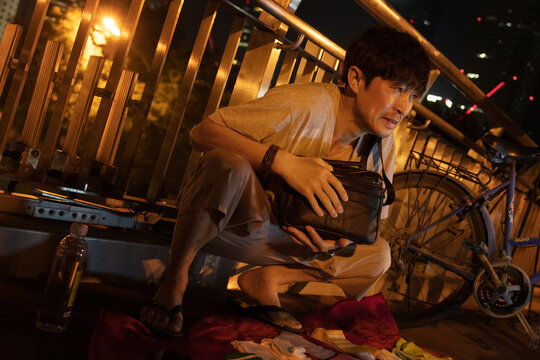 A middle-aged man who stands on the overpass at night