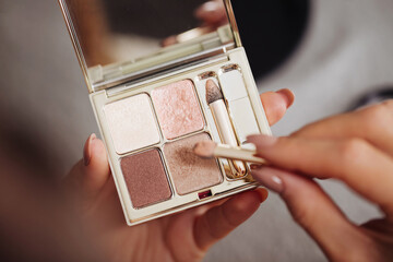 Eyeshadow palette background. Woman holding cosmetics in hand. Girl doing makeup. Premium luxury...