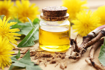 Dandelion root oil, tincture, wine or honey with fresh flowers and leaves on wooden table, closeup, copy space, green medicine, homeoparhy, hair and skin healthy care, detox therapy concept
