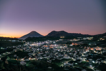 City light of building in Dieng Regency with beautiful sunrise sky and mountain. Stars visible in the sky at dawn. Scooter or Skoter Hill, Dieng, Indonesia