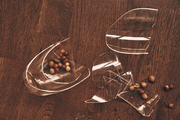 Top view of a transparent mug broken in close-up from under compote with raisins. Pieces of broken glass lie on the floor with space to copy. High quality photo