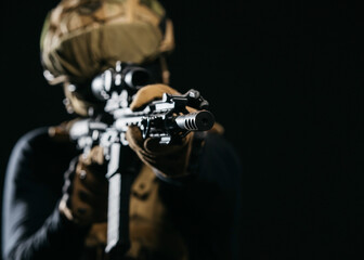 Photo of a confident and courageous military man on a dark isolated background in a camouflage...