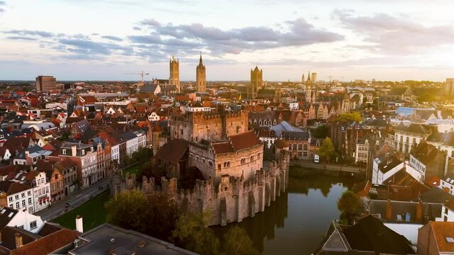 Aerial view of famous places Castle of the Counts next to river Lys. Beautiful architecture and landmarks of the medieval city on a sunset. Ghent, Belgium
